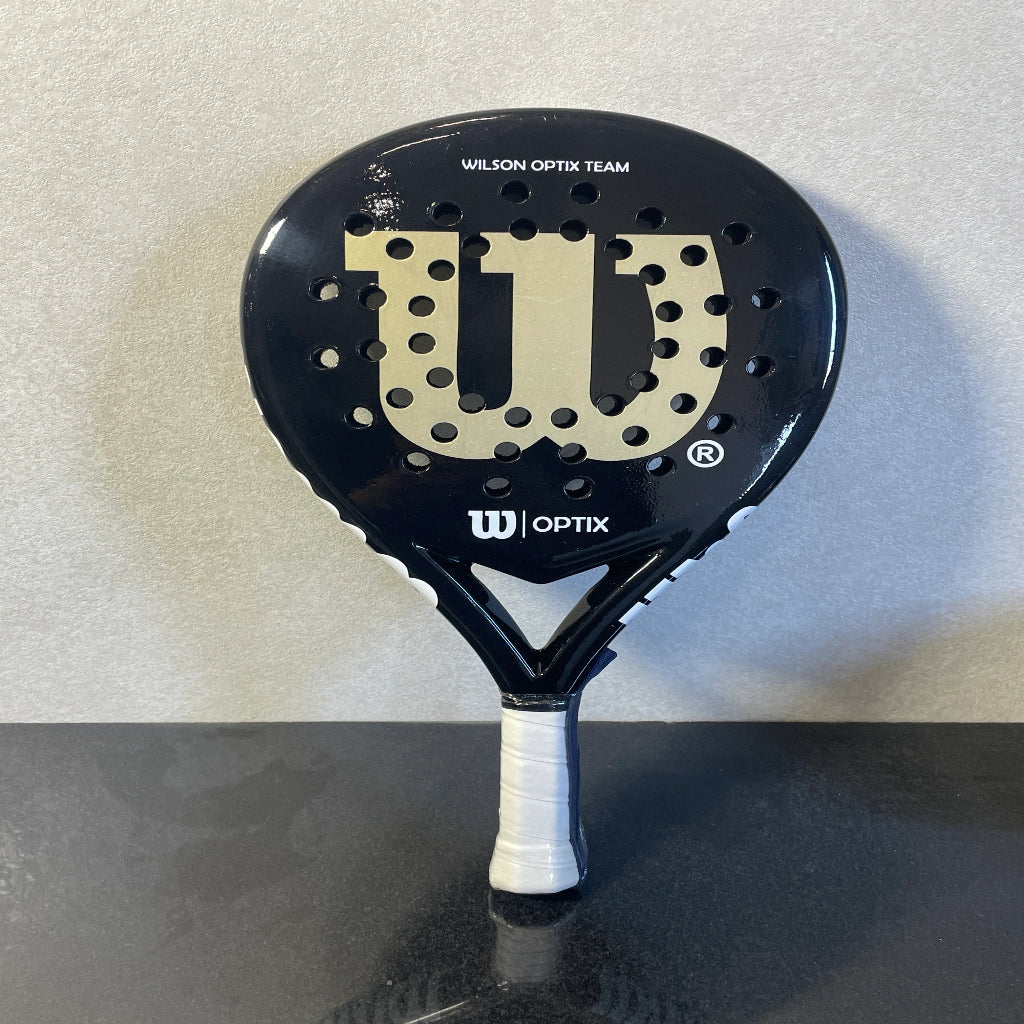 Black Wilson Optix tennis racket on a gray background