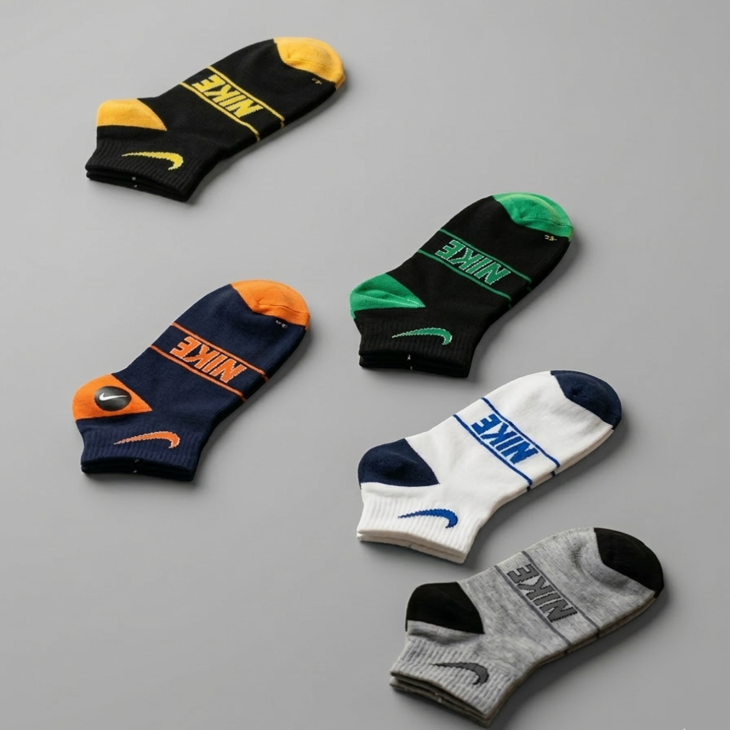 Five pairs of Nike socks in various colors on a gray background