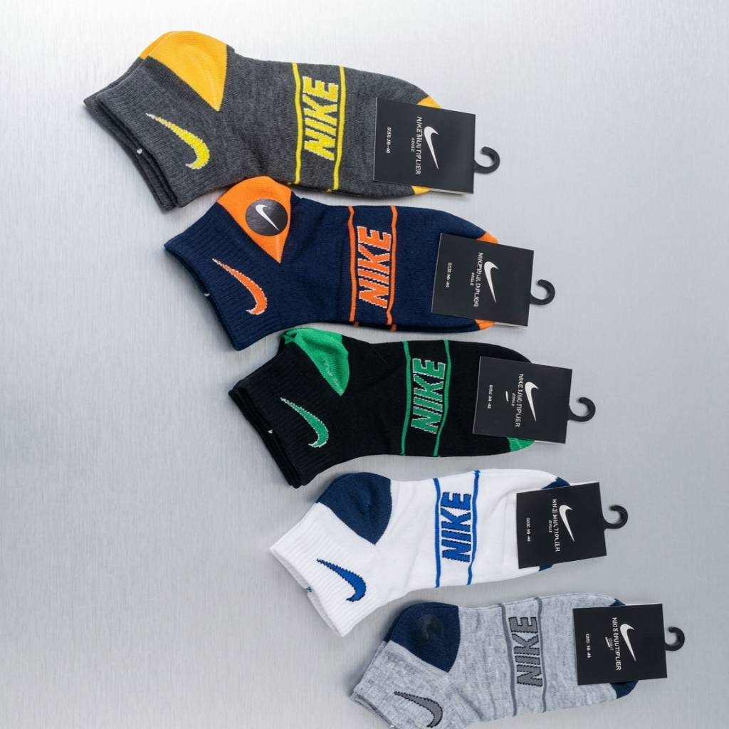 Set of Nike socks in various colors with packaging on a light gray background
