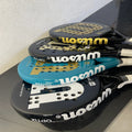 Stack of Wilson tennis rackets on a black surface with a white background
