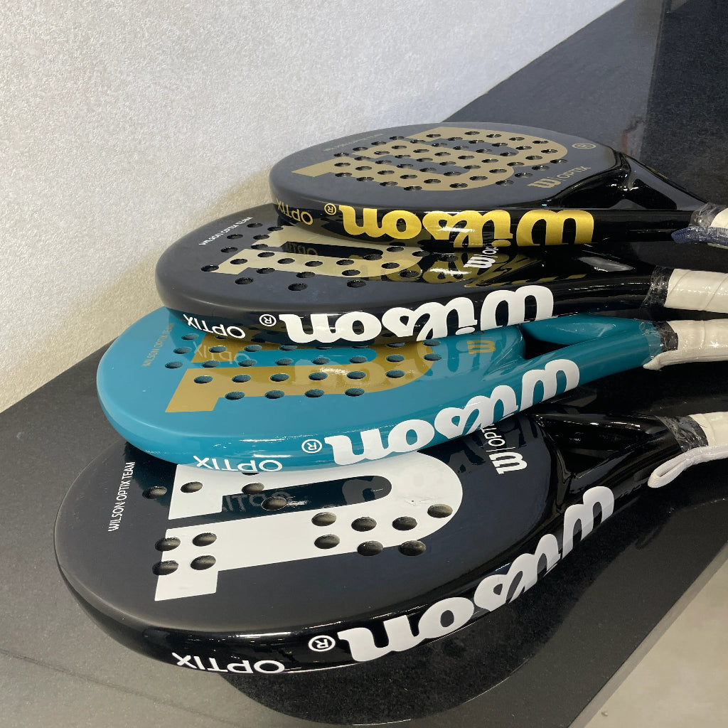 Stack of Wilson tennis rackets on a black surface with a white background