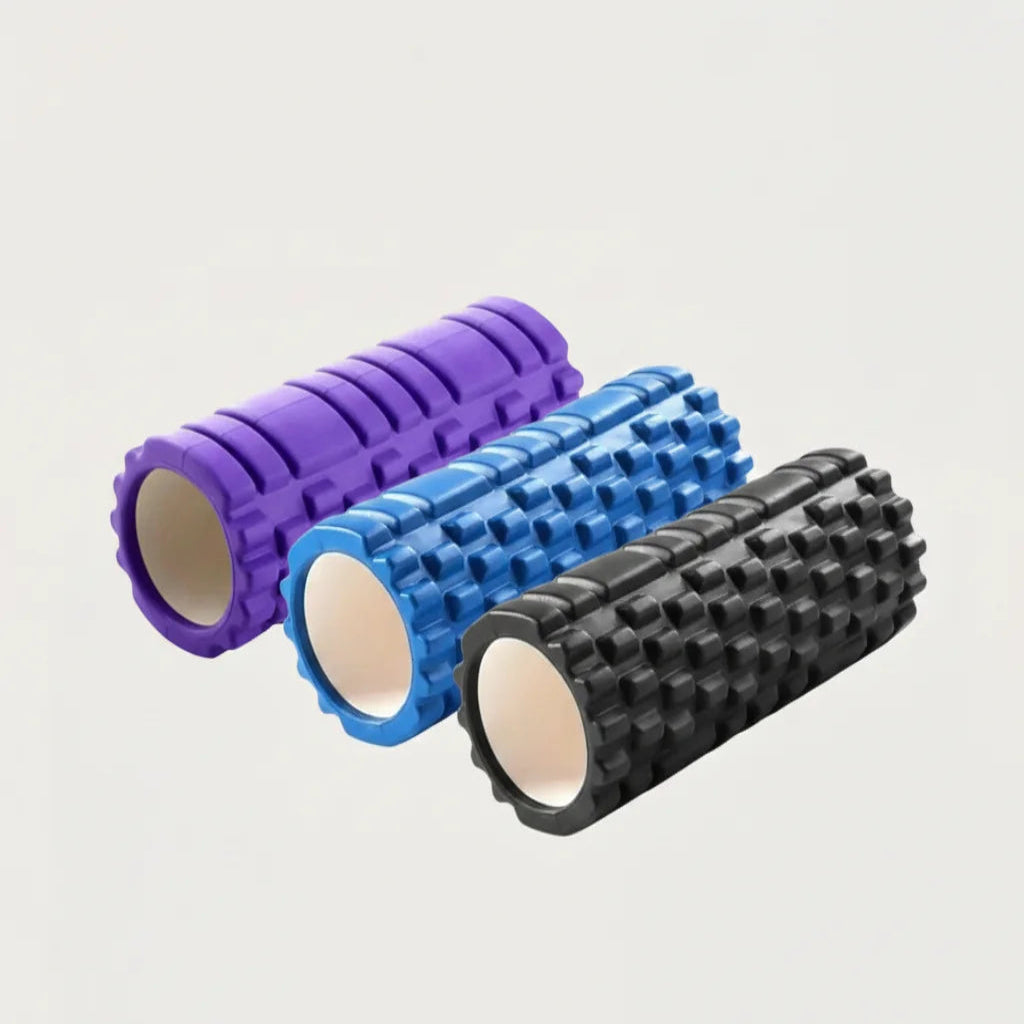 Three foam rollers in purple, blue, and black on a light gray background